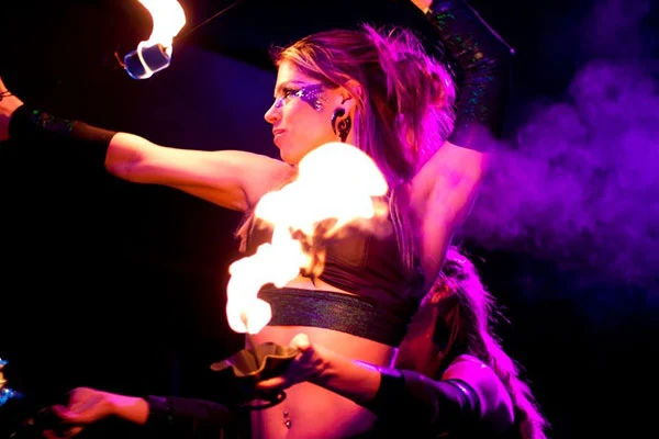 Debby performing on a stage illuminated in violet